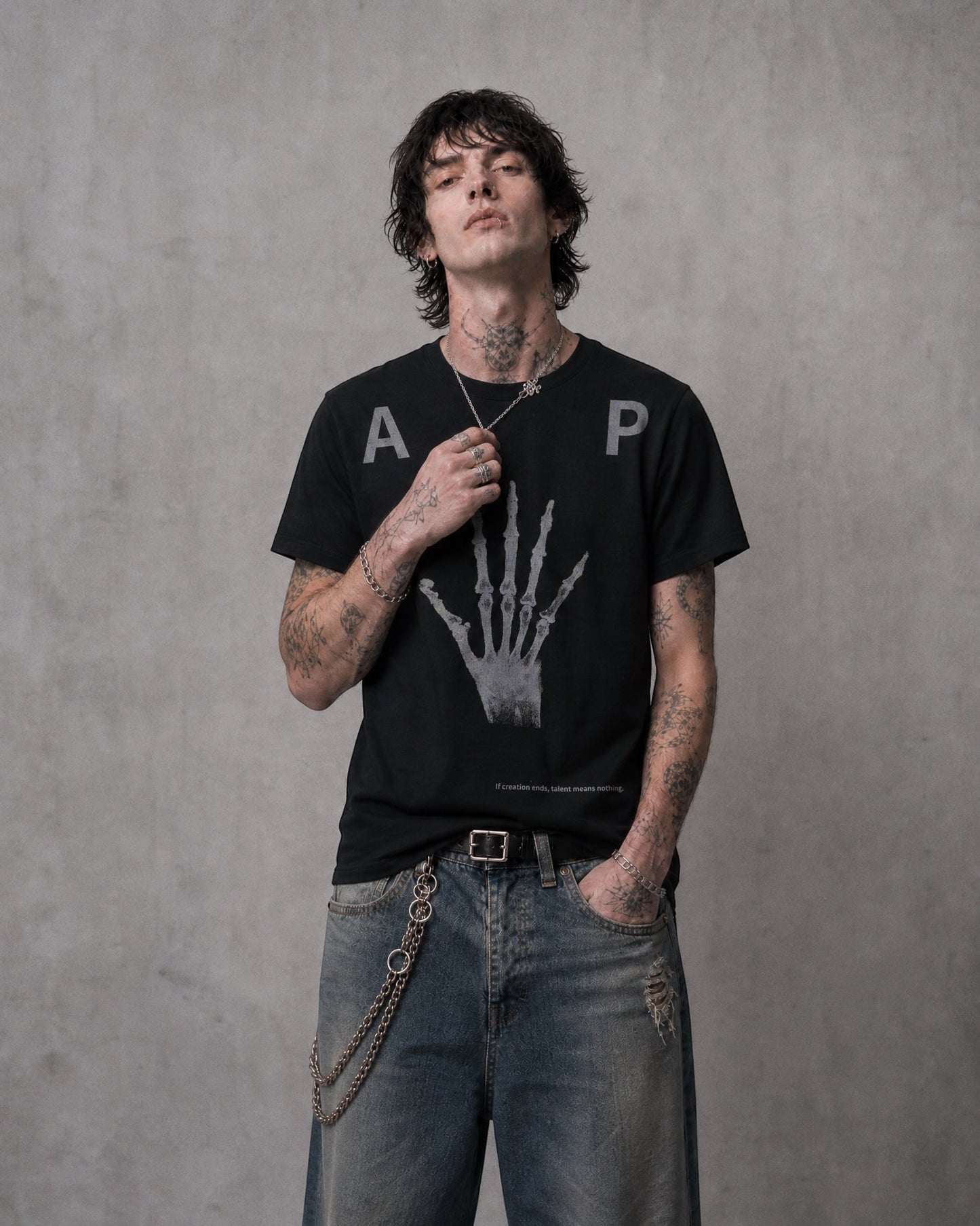 ANTIPROMINDの黒い天竺コットンTシャツ。フロントにスケルトンハンドのグラフィックがプリントされたリラックスフィットのヴィンテージ風デザイン。