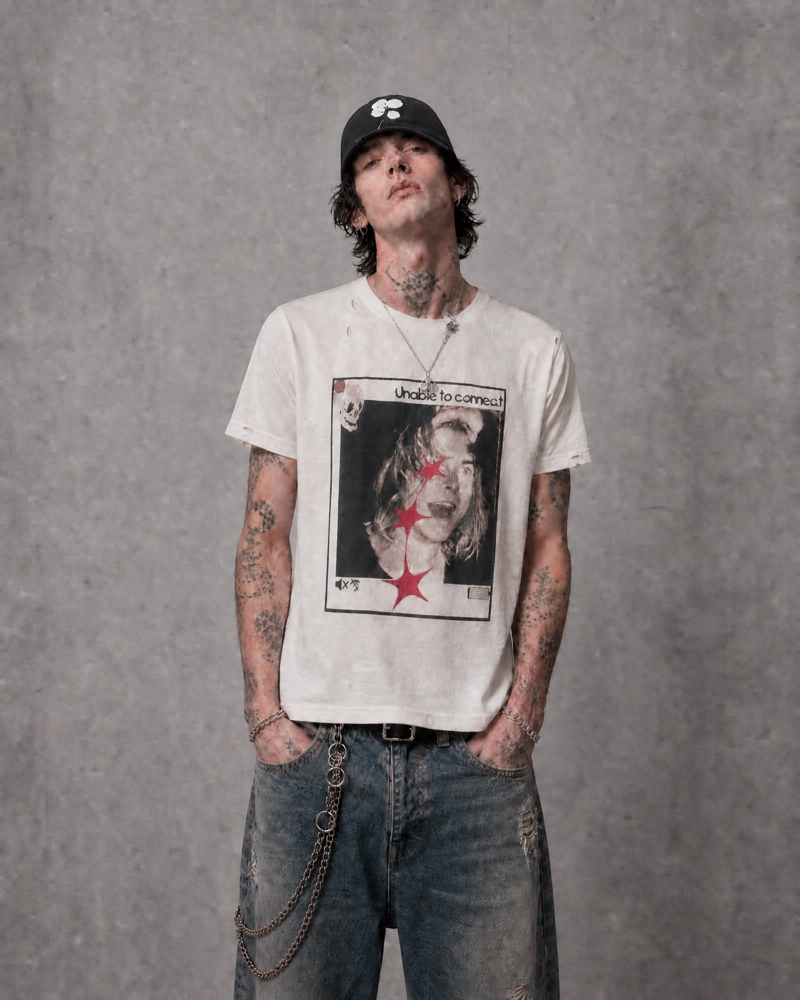 ANTIPROMINDのダメージ加工が施されたヴィンテージ風グラフィックTシャツを着用した男性モデル