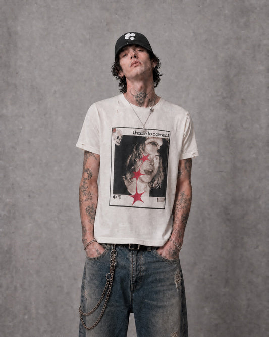 ANTIPROMINDのダメージ加工が施されたヴィンテージ風グラフィックTシャツを着用した男性モデル
