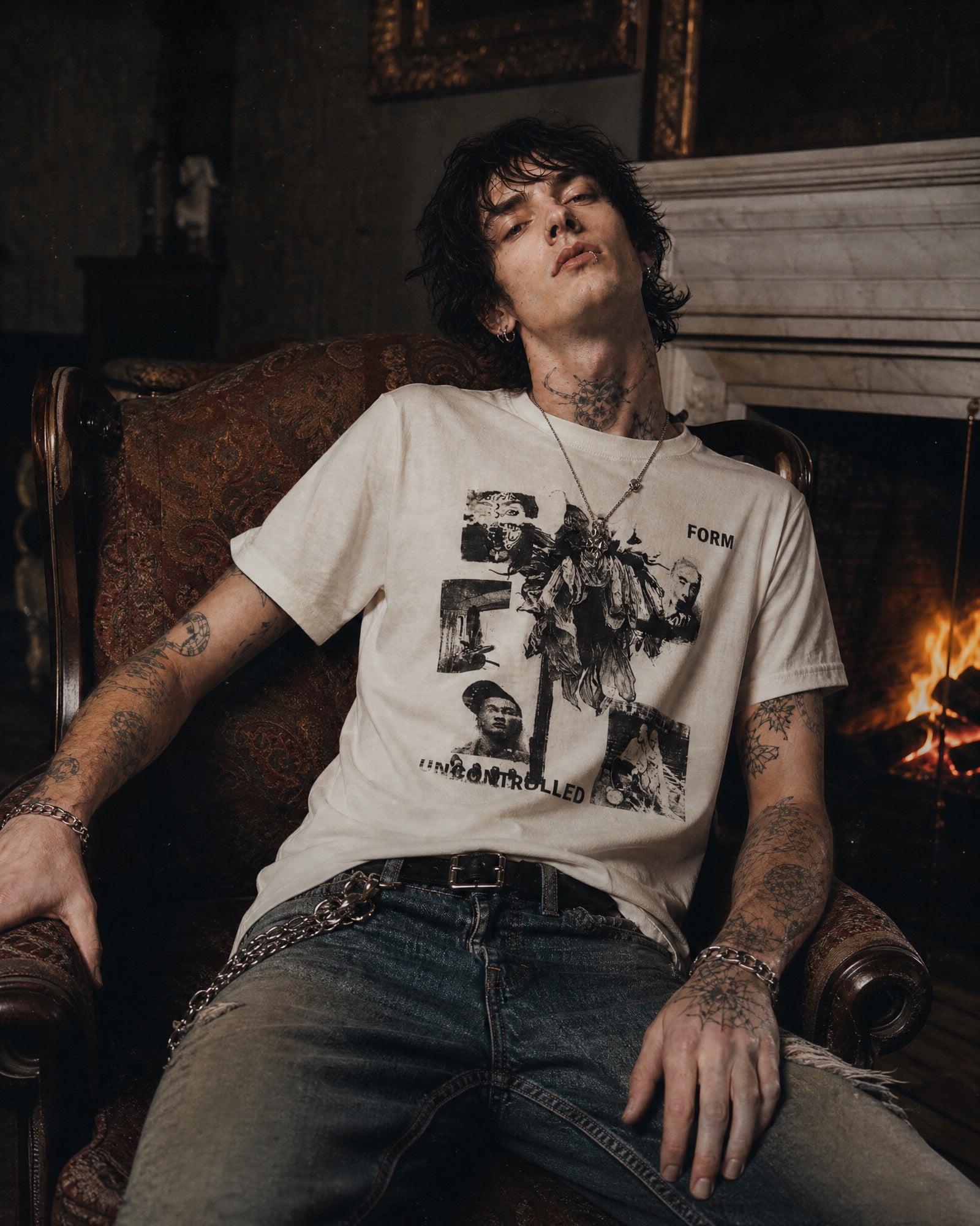 ANTIPROMINDのヴィンテージ風グラフィックTシャツを着用したモデル。オフホワイトの天竺コットン素材にコラージュアートがプリントされたリラックスフィットの半袖Tシャツ。