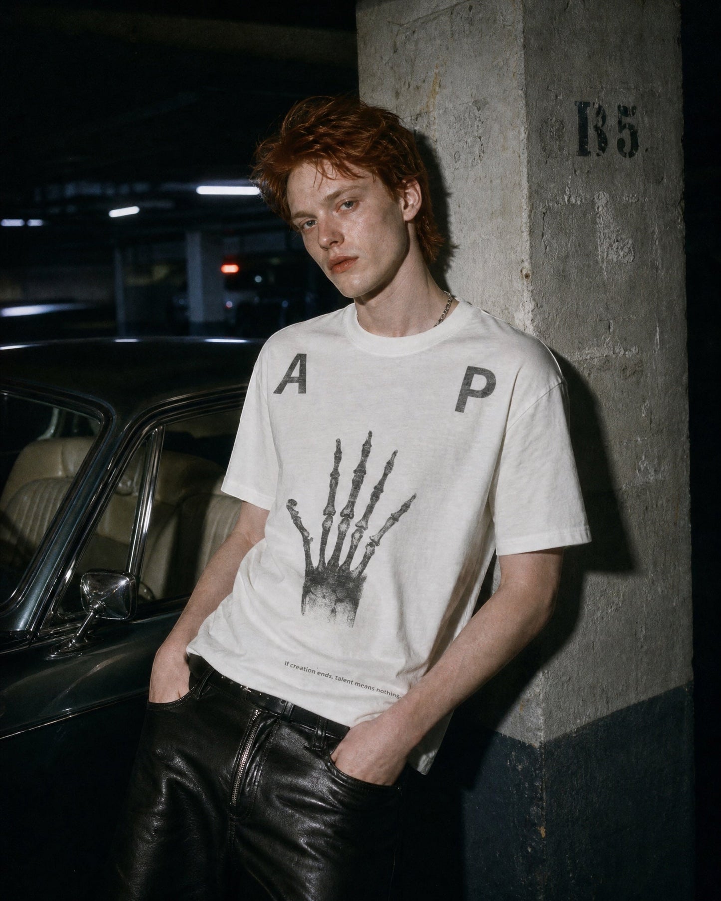 ANTIPROMINDのホワイト天竺コットンTシャツ。スケルトンハンドのグラフィックとヴィンテージ風プリントが特徴のリラックスフィット。