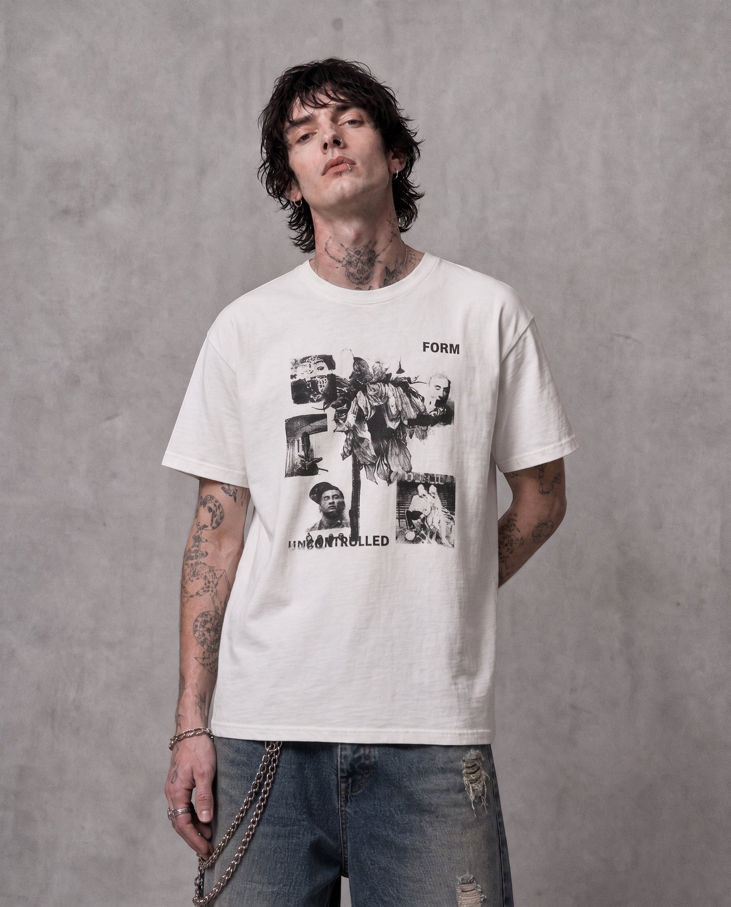 ANTIPROMINDのヴィンテージ風コラージュグラフィックがプリントされた、リラックスフィットの白い天竺コットンTシャツを着用した男性モデル