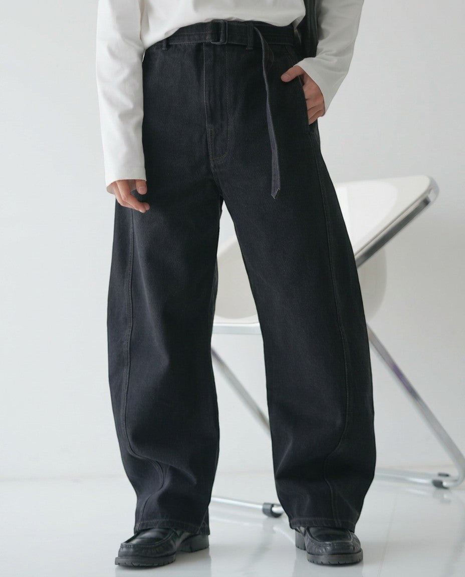 BASISの黒いデニムのカーブパンツ。ベルト付きで、ゆったりとしたシルエットが特徴です。