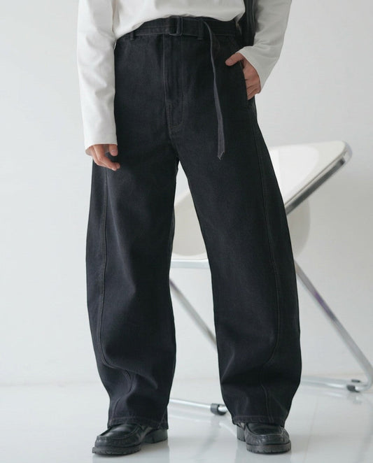 BASISの黒いデニムのカーブパンツ。ベルト付きで、ゆったりとしたシルエットが特徴です。