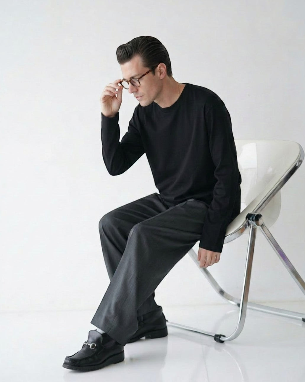 BASISのピマコットン長袖Tシャツ。黒、クルーネック、シンプルなデザイン。男性モデル着用。
