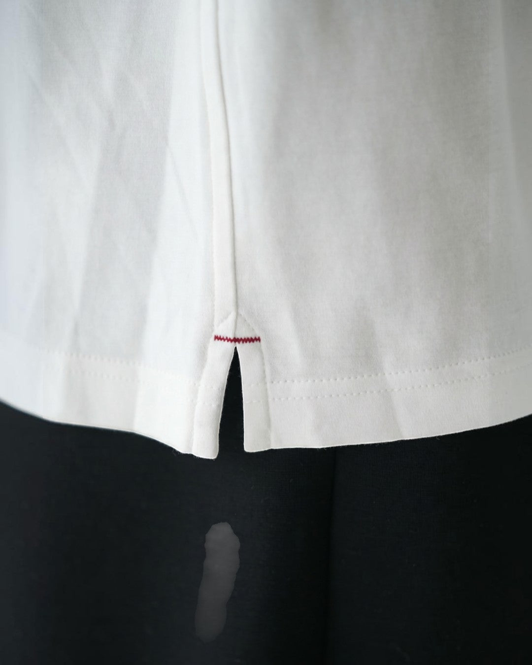 BASISの白いトライアセテートTシャツ。サイドスリットとバータックが特徴。リラックスフィット。