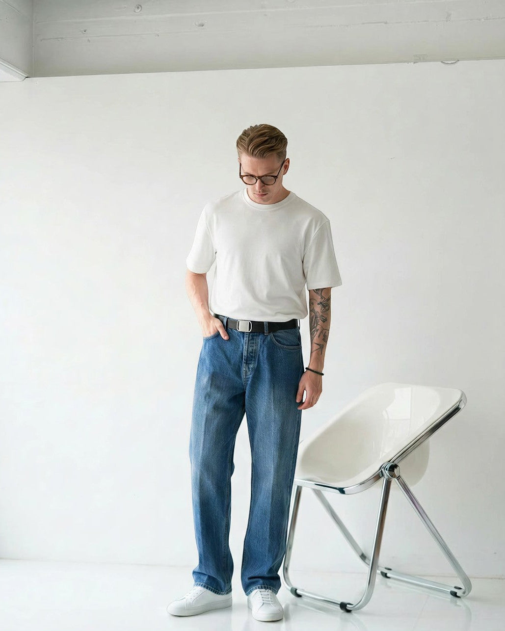 BASISMのブルーデニム、リラックスフィットジーンズ。男性モデル着用。