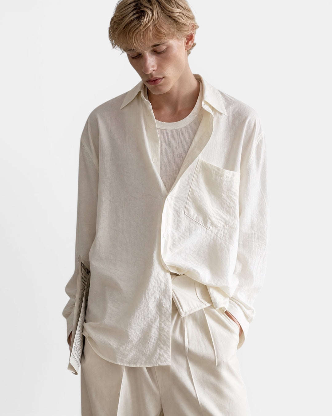 NAMELESS cream textured long sleeve oversized shirt worn by a male model with a ribbed tank top underneath.