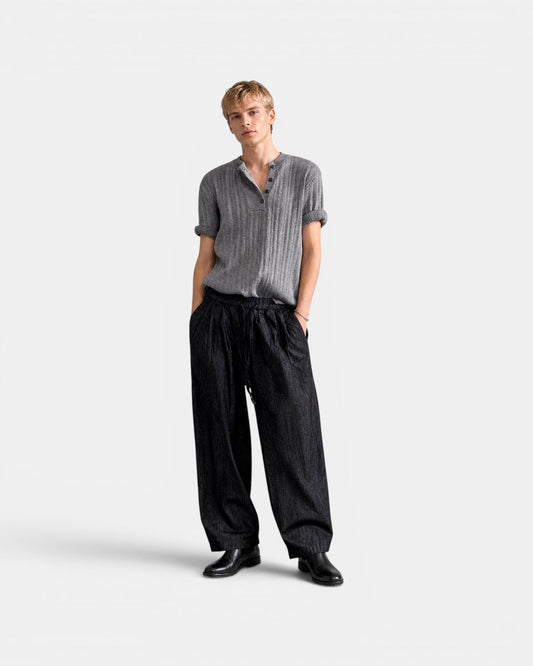 NAMELESS grey ribbed short-sleeve henley knit top with rolled cuffs, worn by a male model with black wide-leg pants.
