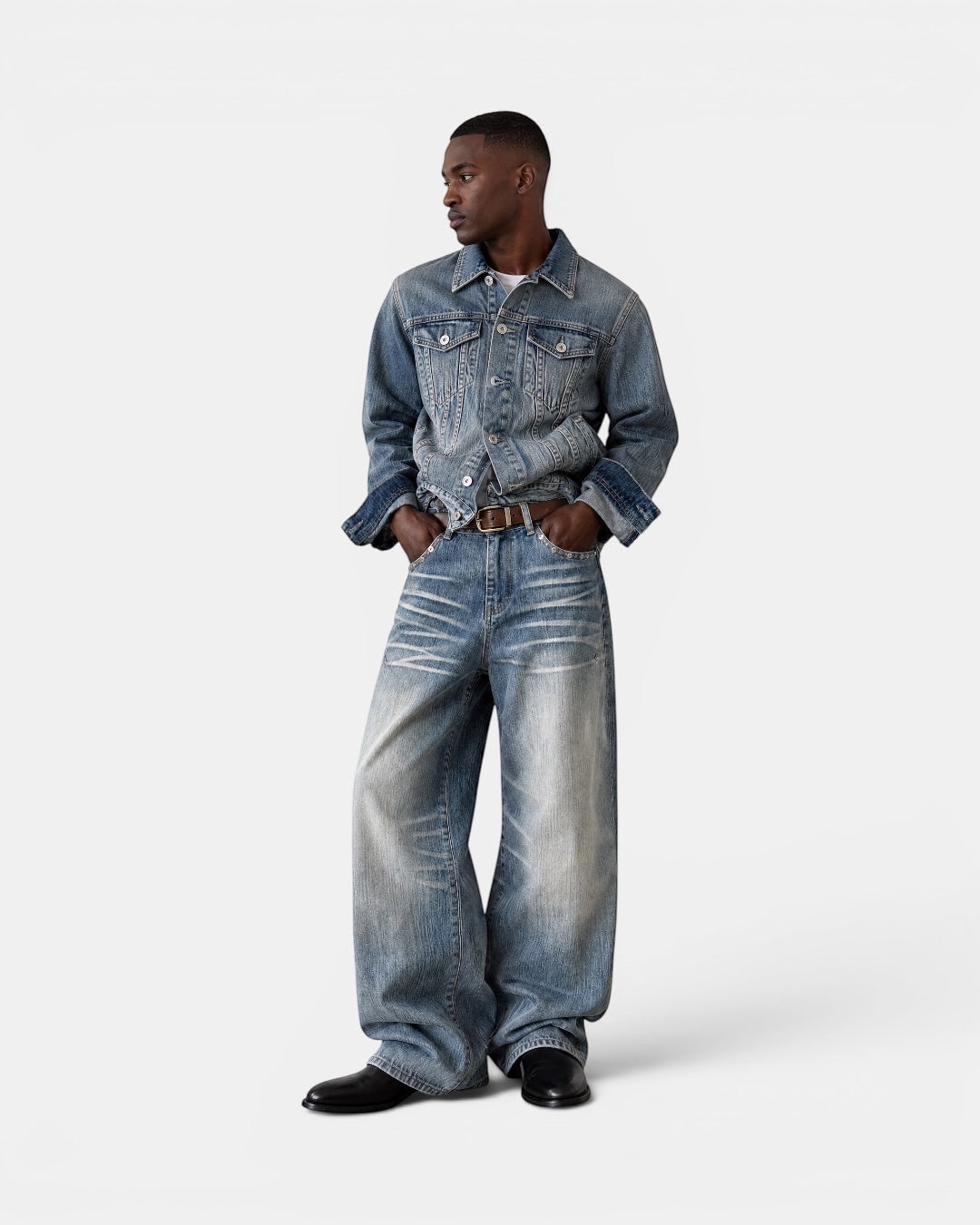 NAMELESS light wash distressed denim jeans with a wide-leg silhouette and authentic fading. Model wears them with a denim jacket and brown belt.