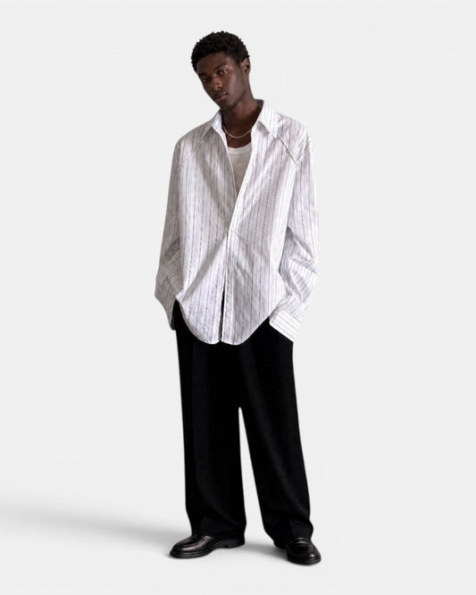 NAMELESS white long-sleeved shirt with subtle blue pinstripes, worn by a male model with black trousers.