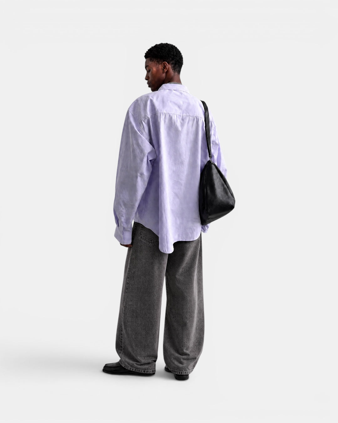 Nameless light purple solid-color long-sleeved oversized cotton shirt worn by a man with dark skin, paired with grey wide-leg jeans.